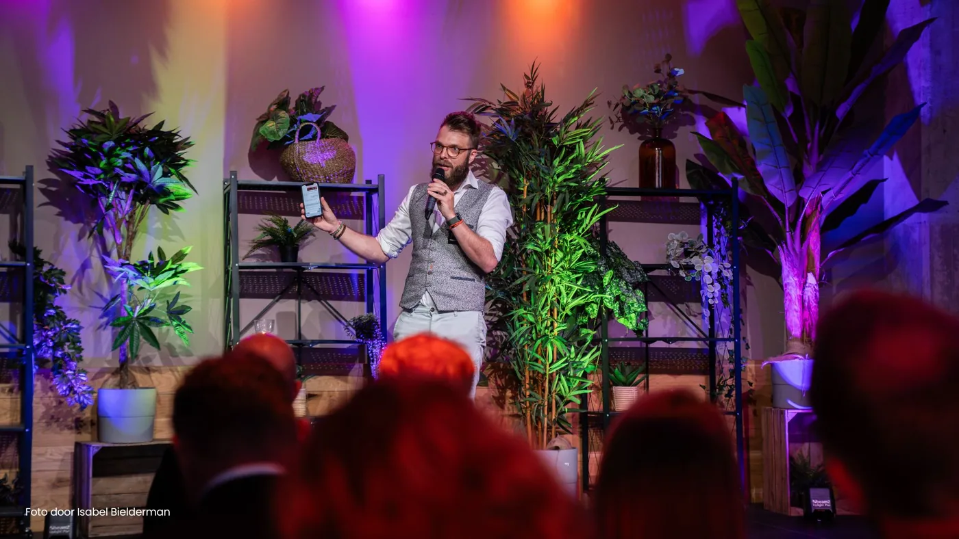 Spreker AI Hendrik van Zwol met microfoon tijdens een humoristische AI lezing