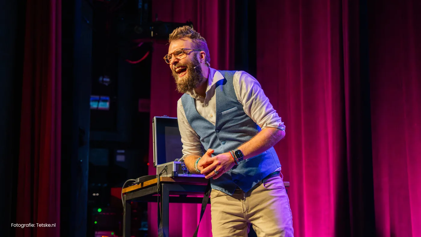 AI spreker Hendrik van Zwol lachend tijdens een theatervoorstelling